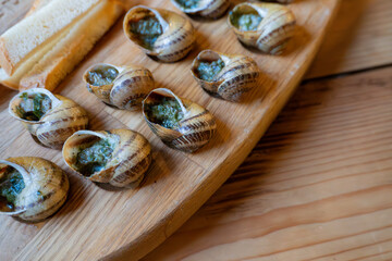Traditional french escargot with garlic butter on wooden board