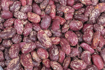 Top view of dried red beans with white spots, close-up, background for product design in the store on a market stall at a farmer's fair.
