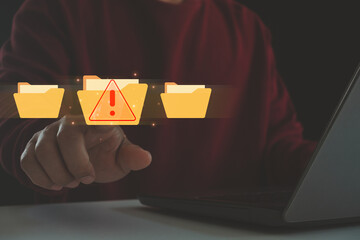 Cybersecurity technology warning alert with hand touching digital folder on laptop computer in...
