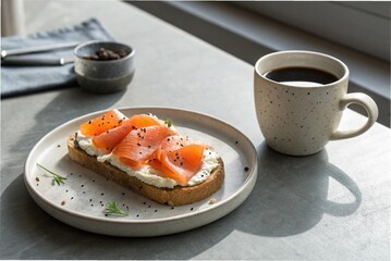 An open-faced sandwich and a cup of black coffee on a minimalist grey tabletop