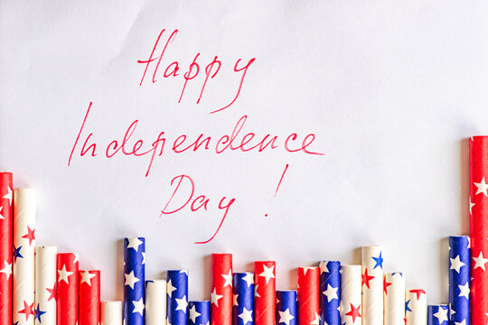 Rolls of disposable wrapping paper decorated with stars next to Happy Independence Day written on a piece of paper
