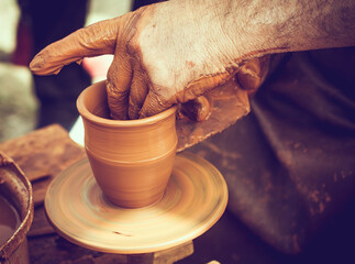 Close-up of a Potter`s hands shaping wet clay on a potters wheel