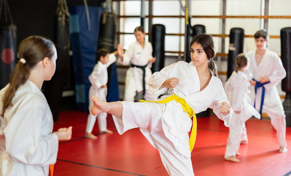 Teenage girls are actively engaged in judo. Children in white kimonos at a martial arts training session - Powered by Adobe