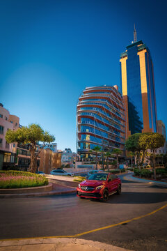 Scenic view of a Mercedes-Benz Sports Coup&eacute; driving around a roundabout in front of the Portomaso Business Tower in Saint Julian's (San Ġiljan), Malta