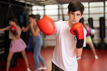 Portrait of a teenage boy in boxing gloves in training. Boxing classes for children