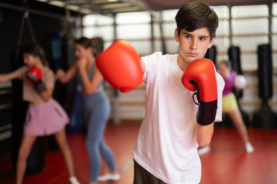 Portrait of a teenage boy in boxing gloves in training. Boxing classes for children
