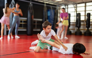 Boys practice self-defense techniques during sparring. Children learn grip in wrestling training