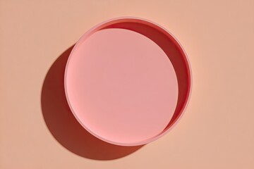 A pale pink circular tray on a peach background