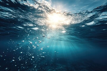 Sunlight streams through ocean surface, bubbles rise