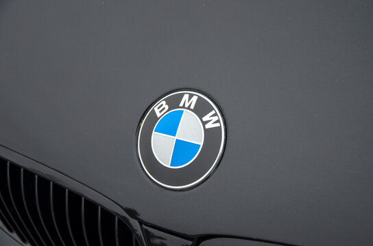 Close-up of a BMW emblem on a dark-colored car, showcasing the iconic blue and white roundel