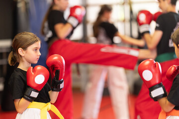 Boy and a girl in red boxing gloves work in sparring, they practice punches and practice stance. Children's boxing and self-defense training © JackF
