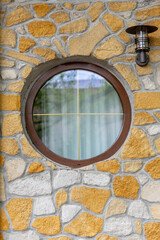 A Circular Window Embraced by a Stone Wall that Exudes Rustic Charm and Character