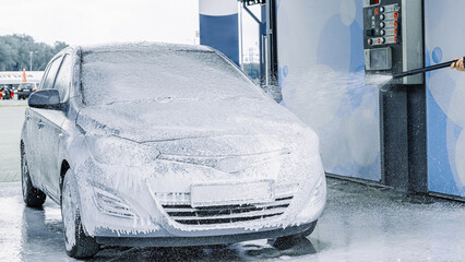 Man cleaning car. Spray hose foam soap. Car wash water shine exterior.