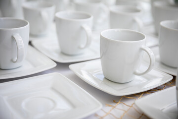 An Elegant Set of White Cups Perfectly Arranged on Plates for Exquisite Dining Experiences