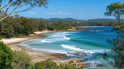 Coastal beach scene with turquoise water and sandy shore. Lush trees and hills in the background