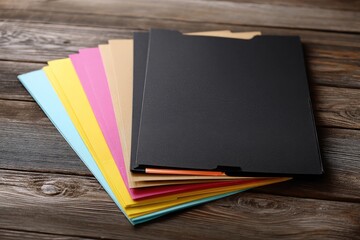 Colorful file folders stacked on a wooden table