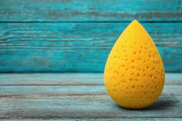 Bright yellow sponge on teal wood