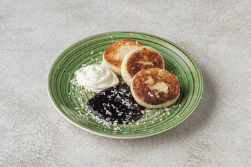 Syrniki Cheesecakes Appetizing cottage cheese pancakes with cream sauce a plate.