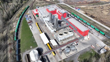 Large production facility with a railroad branch line. A freight train arrived to load products to a large industrial enterprise.