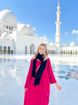 Woman in traditional Arab clothing, abaya, standing in Sheikh Zayed Grand Mosque in Abu Dhabi, UAE.