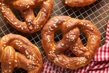 Tasty pretzels with salt on wooden table, top view