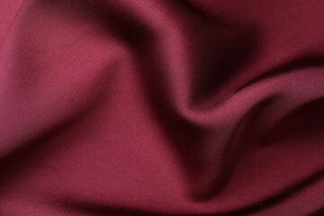 Crumpled burgundy silk fabric as background, top view