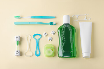 Different oral care products and teeth models on beige background, flat lay