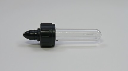 Clear glass dropper with black rubber bulb on a white surface studio shot
