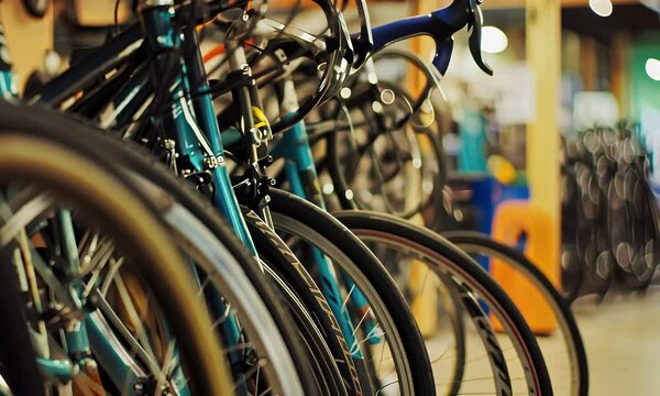 Close Up View of Teal and Black Bicycles with Silver Wheels in Bicycle Shop with Blurred Background