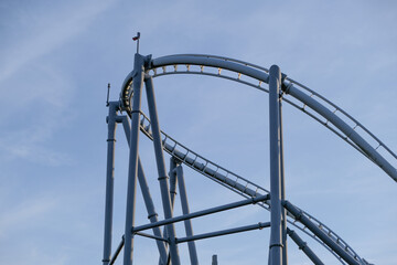 A roller coaster with a blue sky in the background