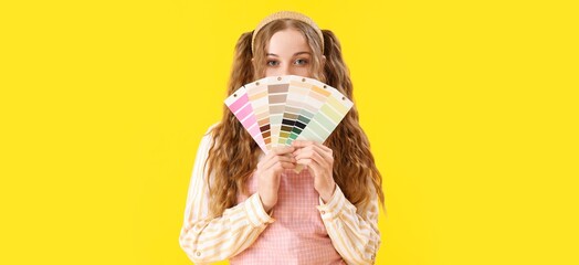 Female interior designer holding color palettes on yellow background