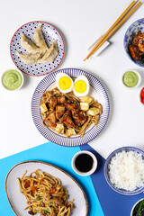Composition with tasty Chinese dishes on light background