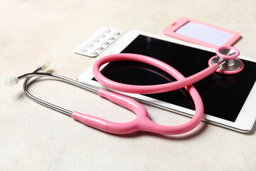 Stethoscope, tablet computer, badge and pills on light background