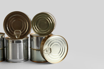 Different tin cans with fish on white background