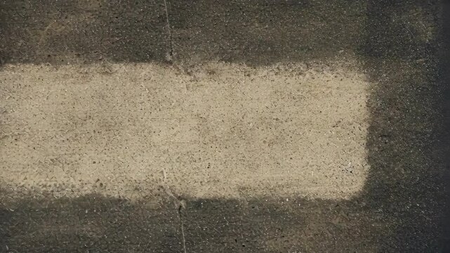 A minimalistic concrete surface with a faded rectangular patch.
