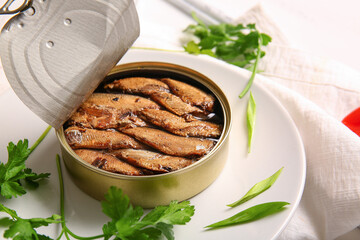 Plate of canned smoked sprats with parsley on white wooden  background