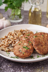 Cutlets with buckwheat, mushrooms and parsley on grey grunge table in kitchen