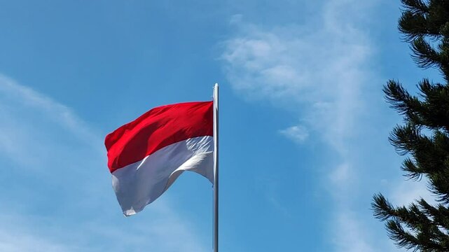 Indonesian Flag waving under the blue sky in Independence Day