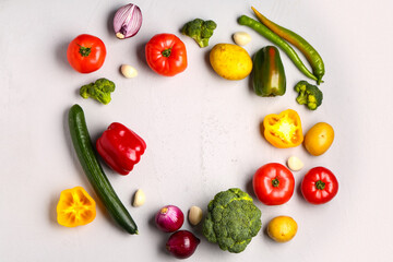 Frame made of different fresh vegetables on grey background