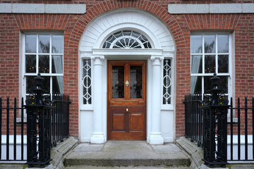 Front door of old Georgian style townhouse with fanlight window above