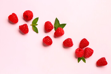 Many fresh raspberries and mint on pink background