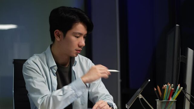 Male coder or developer working overtime using a computer display in problem solving at workplace.