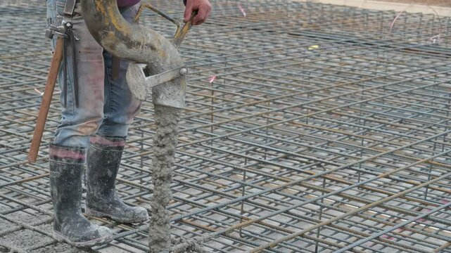 operaio al lavoro in un cantiere edile con una betoniera sparge calcestruzzo