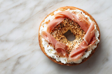 Creamy bagel topped with smoked ham and sesame seeds, perfect for breakfast or brunch