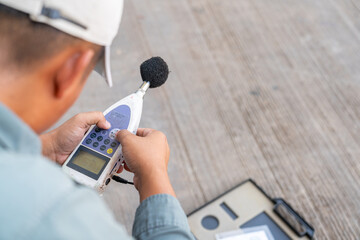 The environmental monitoring officer is setting up the sound level meter.