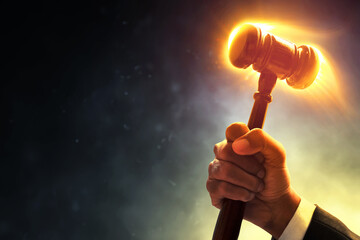 Judge hand holding hammer with fire burning effect on dark smoke background