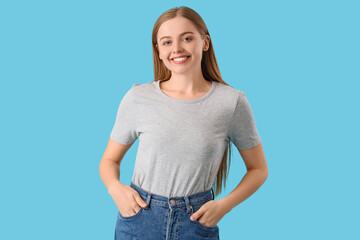 Obraz premium Young woman in stylish grey t-shirt on blue background