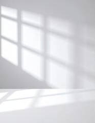 A bright white wall softly illuminated by warm sunlight streaming through a nearby window, creating gentle shadows and a serene atmosphere.