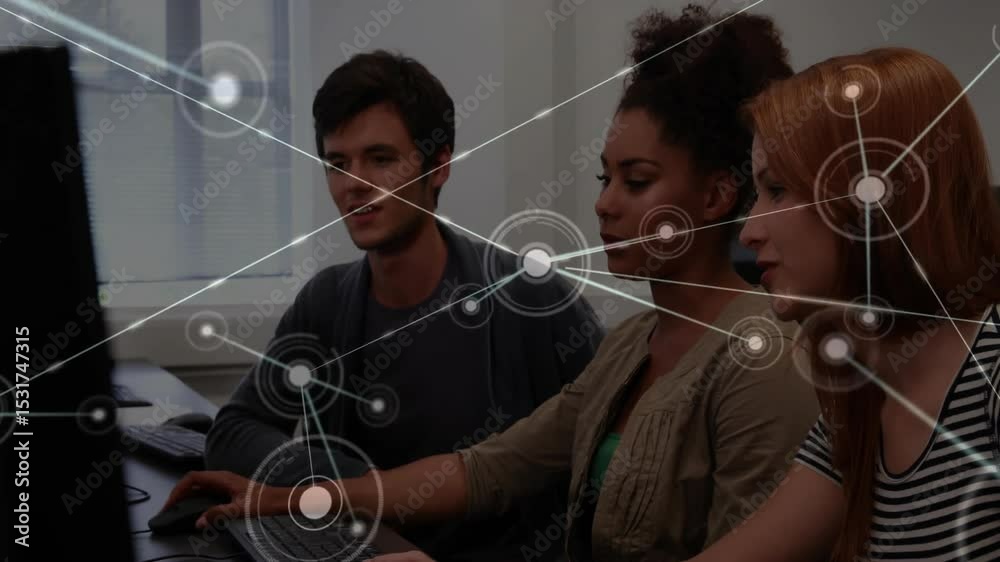 Poster team at computers clicking mouse and visualizing network overlay to represent data flow in tech lab