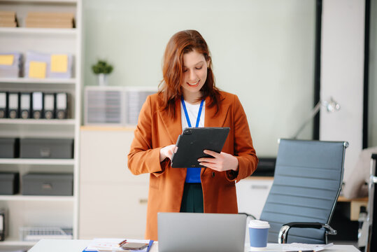 businesswoman working with working notepad, tablet and laptop documents talking on the smartphone, tablet